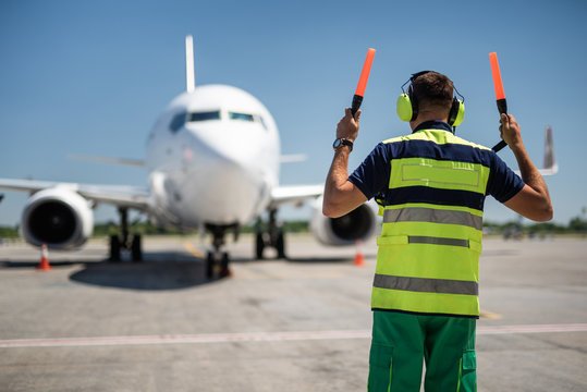 Airport ground crew directing aircraft